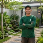 Pekerja Juragan Taman tersenyum setelah menyelesaikan proyek taman